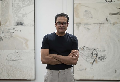 Portrait de Jitish Kallat devant ses œuvres.