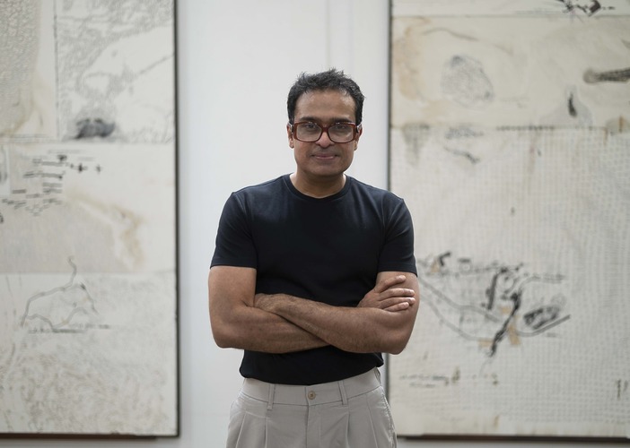 Portrait of Jitish Kallat in front of his works.
