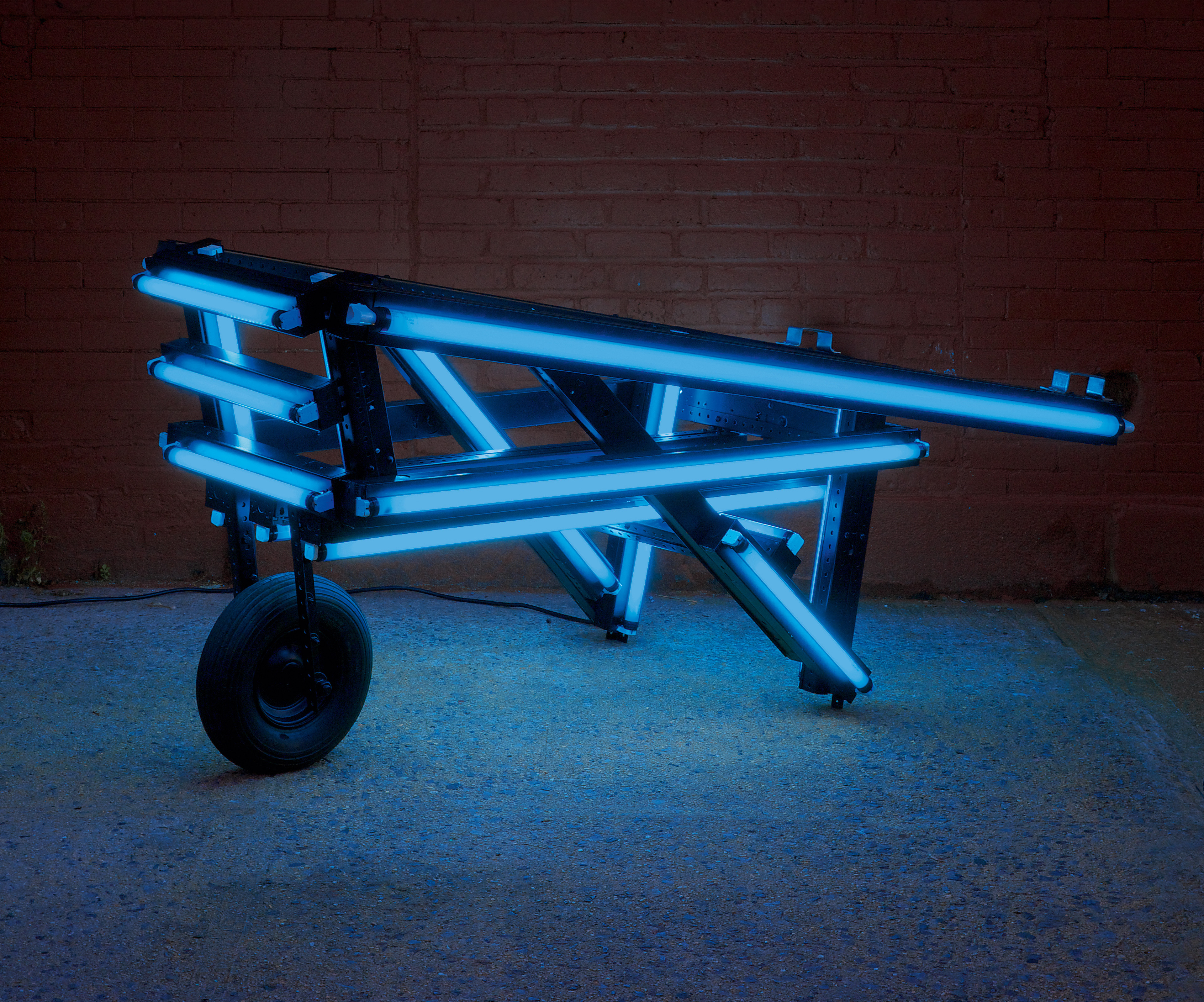 Iván Navarro, Flash light (blue), 2006 Fluorescent light tubes, plastic sleeves, metal fixtures, wheel, video (8:00min) and electric energy 65 × 190 × 80 cm